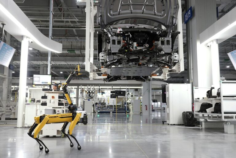 robot industriel autonome dans l'assemblage d'un vehicule electrique en usine de production automobile moderne